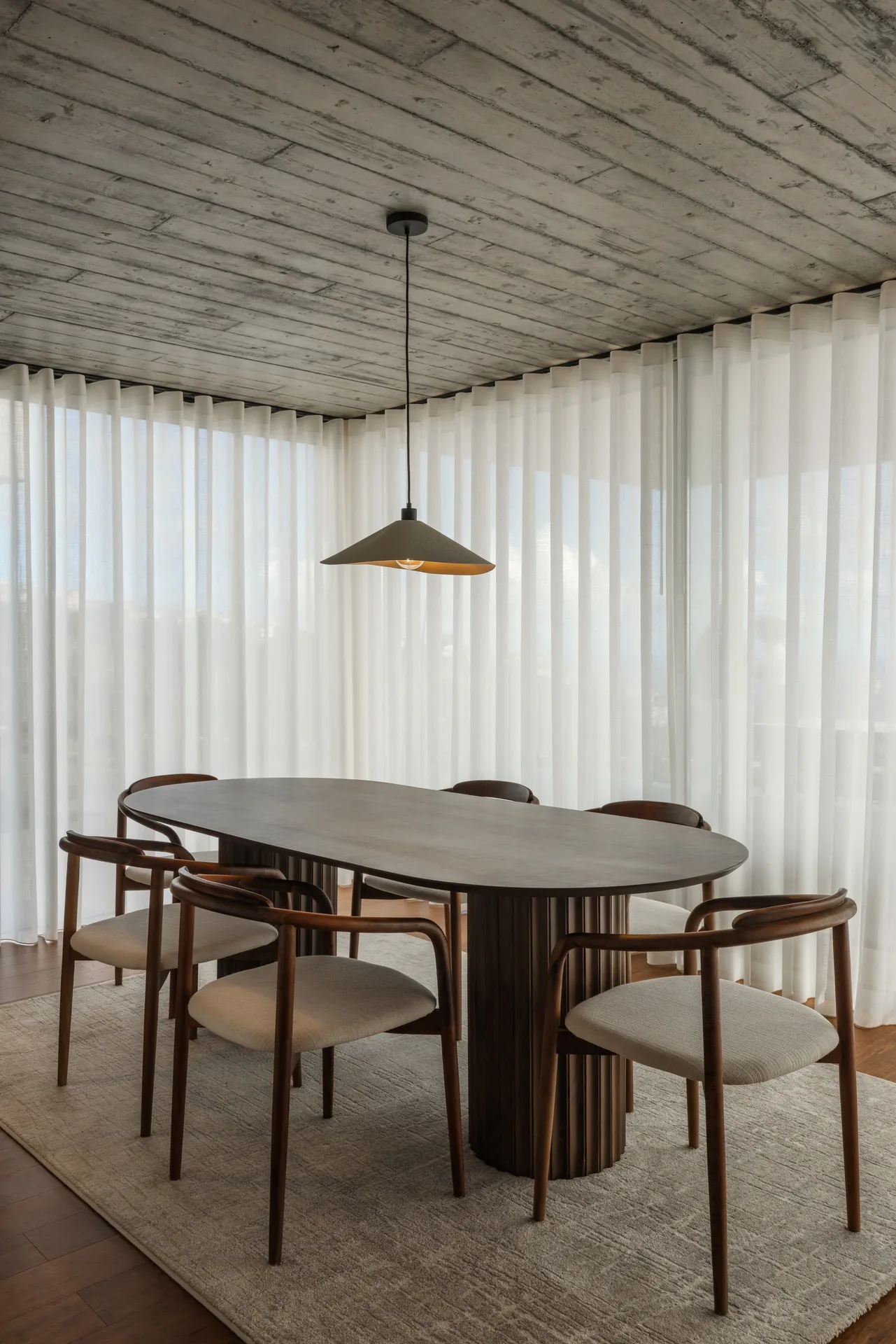 Sala de jantar com mesa oval, nas Casas no Salão, na Calheta.
