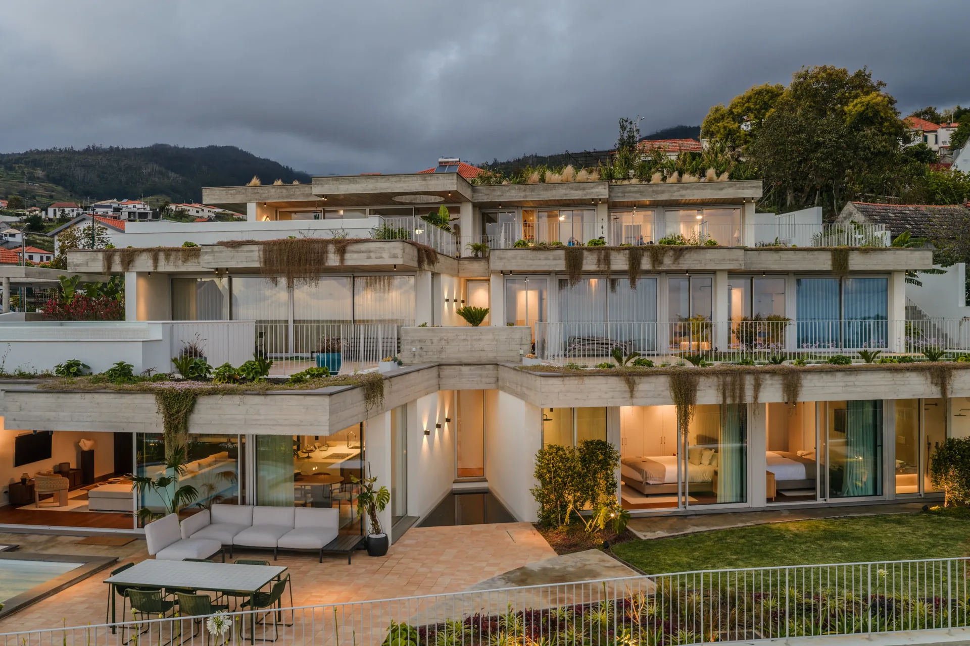 Conjunto das Casas no Salão implantado na encosta, ao anoitecer.