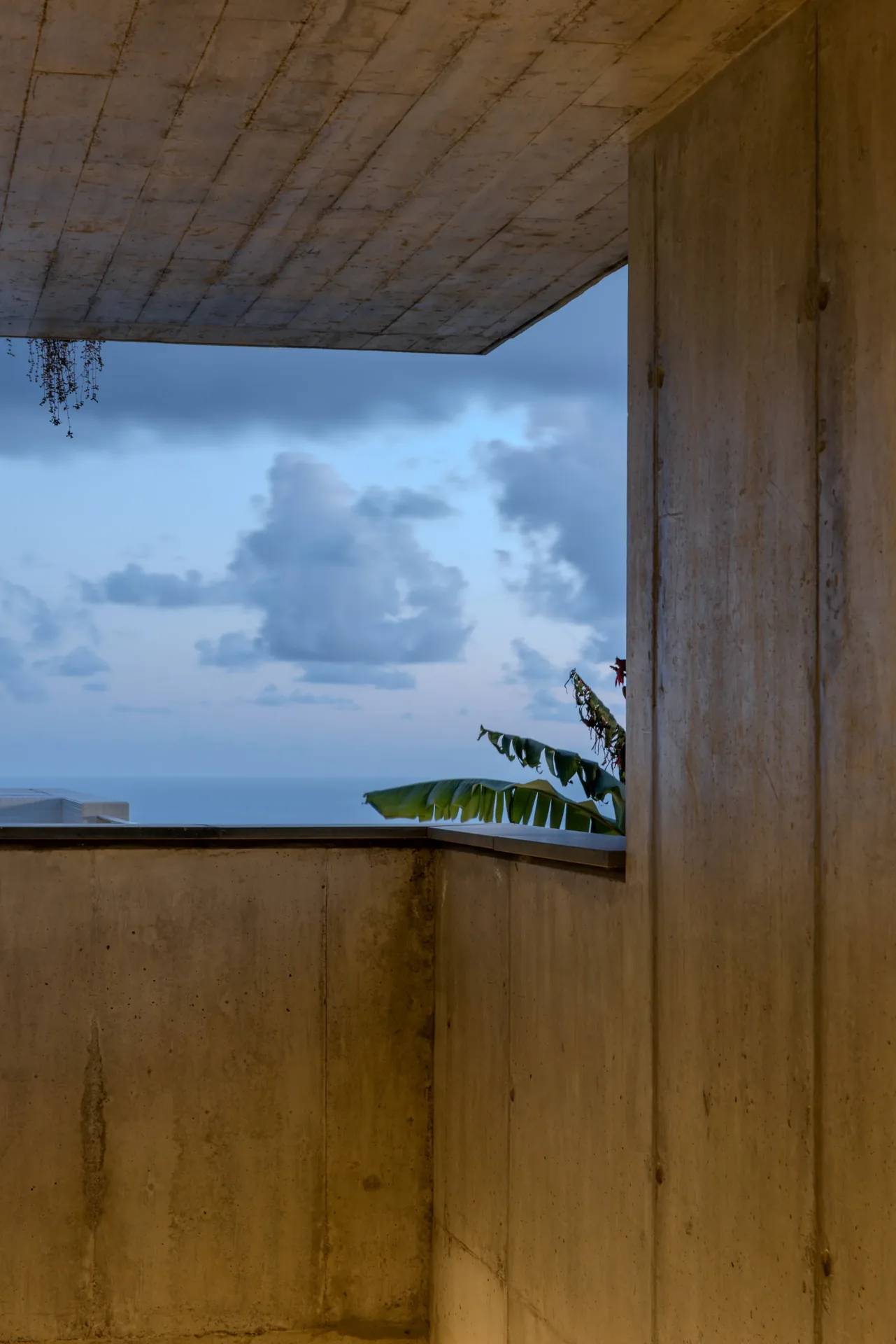 Vão em betão a emoldurar o céu e o mar, nas Casas no Salão.