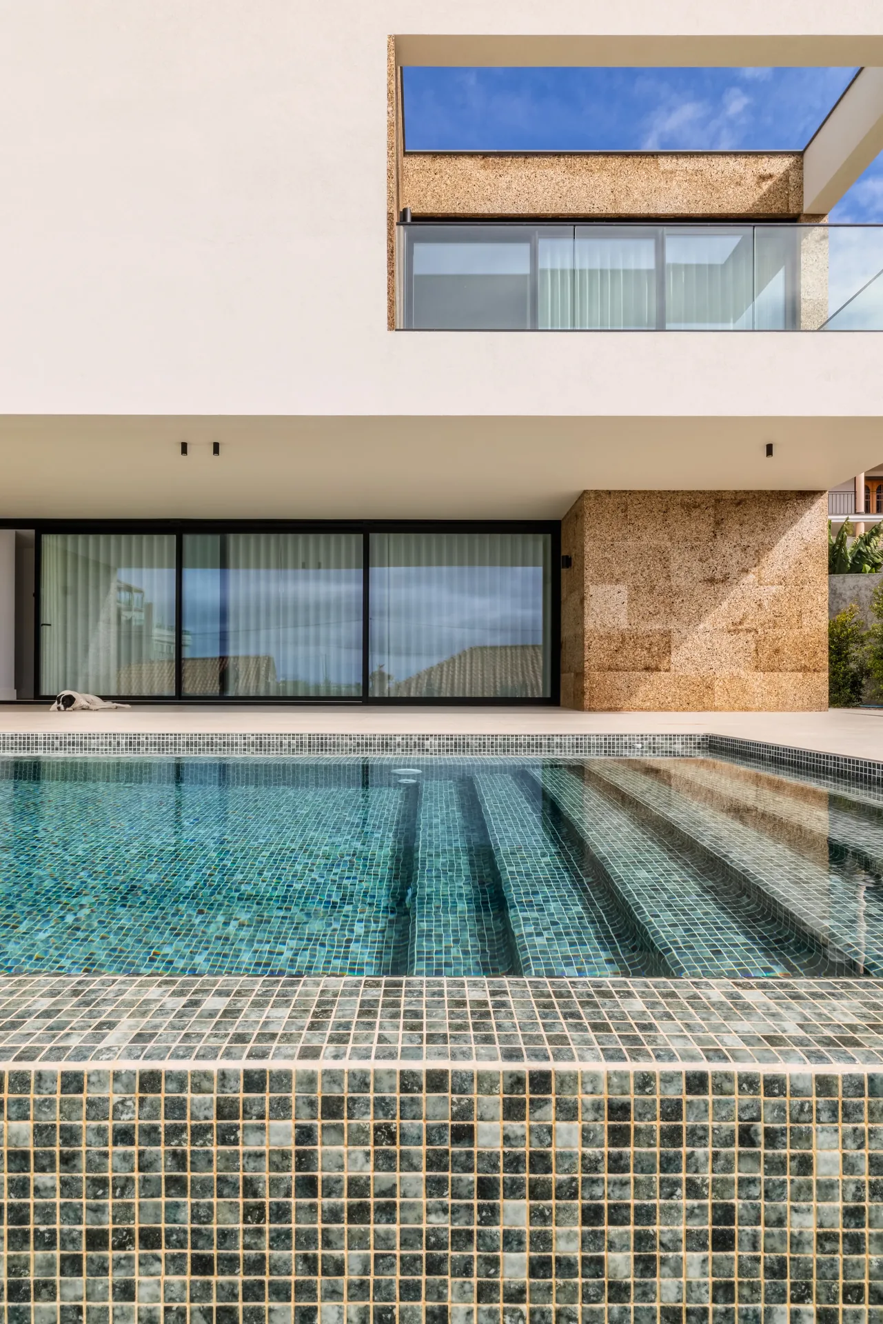 Piscina revestida a mosaico e o volume superior da Casa na Casa Branca.