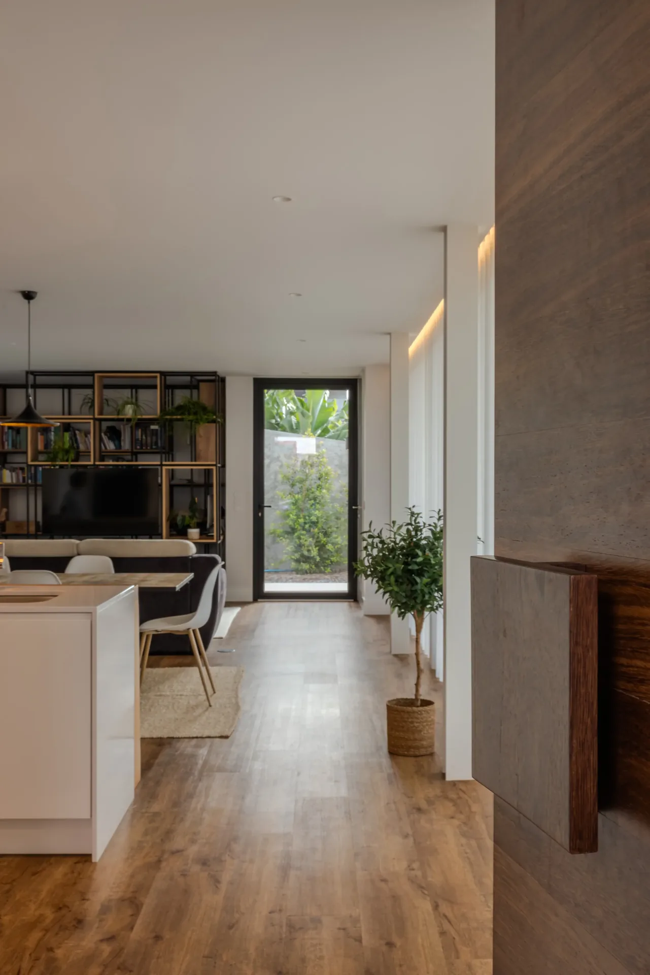 Sala e cozinha em open space, com pavimento em madeira, na Casa na Casa Branca.