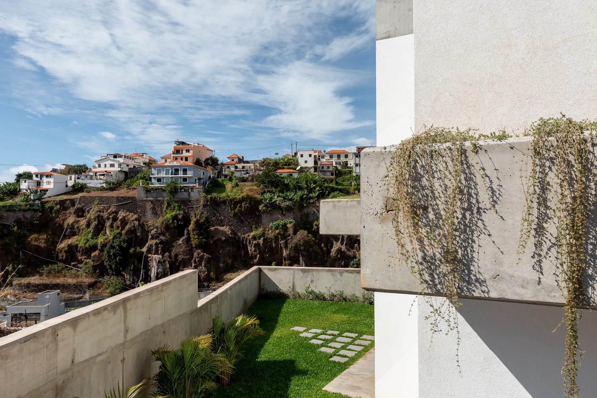 Terraço com floreira suspensa e vista para o mar, na Casa no Serrado da Adega.