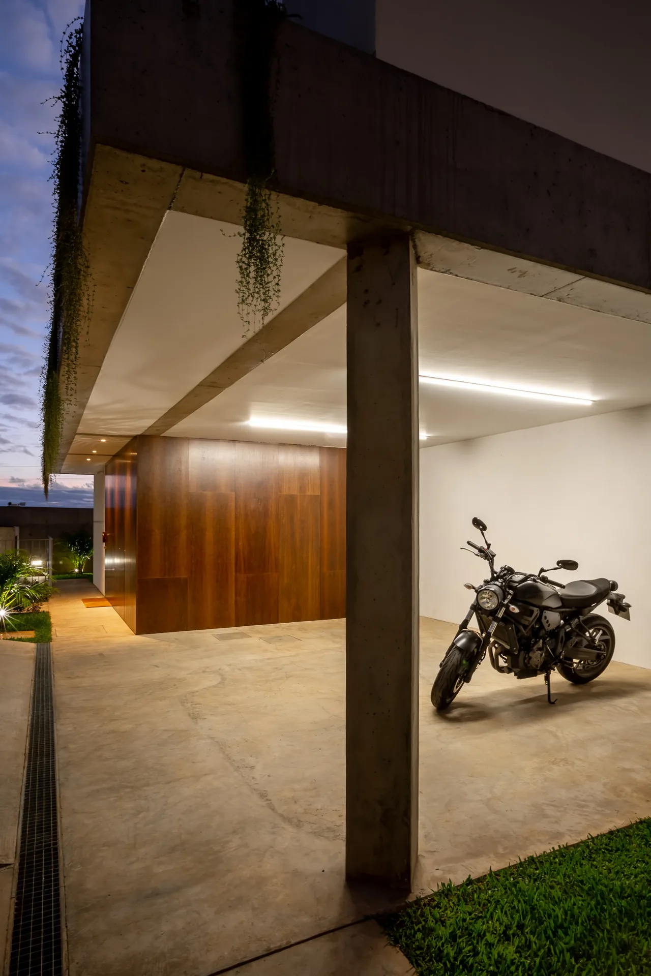 Estacionamento coberto revestido a madeira de sucupira, na Casa no Serrado da Adega.